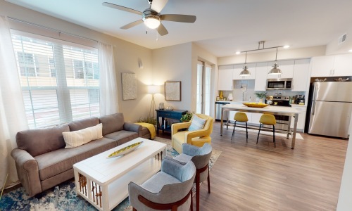 a living room with a couch, tables and chairs