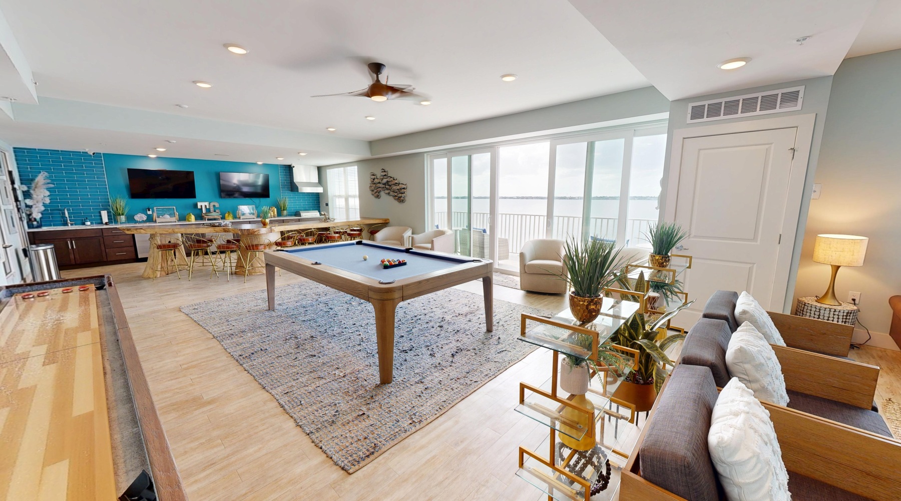 a room with a table chairs and a couch view of the river